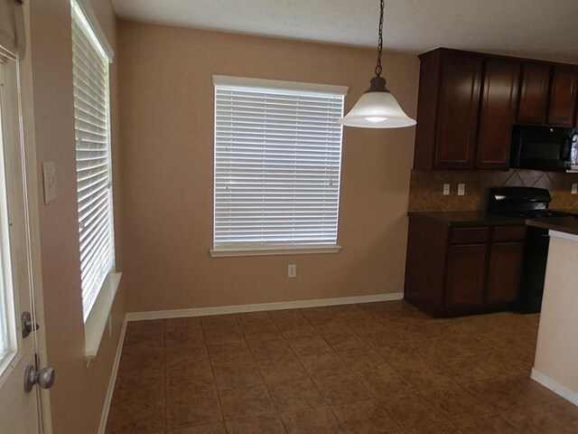 22303 Bridgestone Ridge Dr, Spring, TX 77388 - kitchen with black microwave, tasteful backsplash, decorative light fixtures, and tile patterned flooring