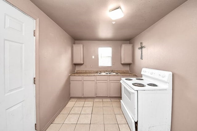 6821 Haight St, Houston, TX 77028 - kitchen with white electric range, light tile patterned flooring, and light countertops