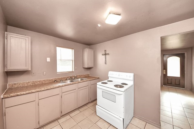 6821 Haight St, Houston, TX 77028 - kitchen featuring white electric range, light tile patterned floors, and light countertops