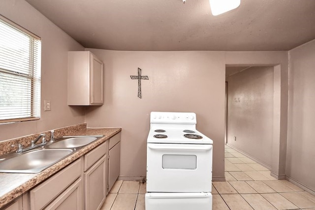 6821 Haight St, Houston, TX 77028 - kitchen featuring white range with electric stovetop, light tile patterned floors, and healthy amount of natural light