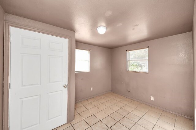 6821 Haight St, Houston, TX 77028 - unfurnished bedroom featuring multiple windows and light tile patterned floors
