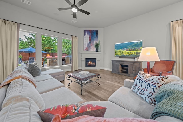 30 Madrone Terrace Pl, Tomball, TX 77375 - living area with a ceiling fan, wood finished floors, and a lit fireplace