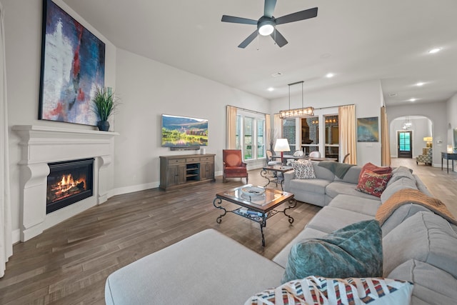30 Madrone Terrace Pl, Tomball, TX 77375 - living area featuring arched walkways, a ceiling fan, wood finished floors, a glass covered fireplace, and recessed lighting
