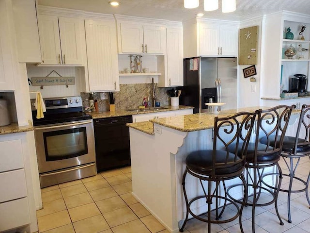 23002 Vida, Galveston, TX 77554 - kitchen with stainless steel appliances, open shelves, a kitchen island, light tile patterned floors, and white cabinets