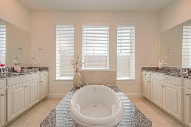 47 Monarch Trl, Sugar Land, TX 77498 - full bath with two vanities, a tub with jets, and tile patterned floors