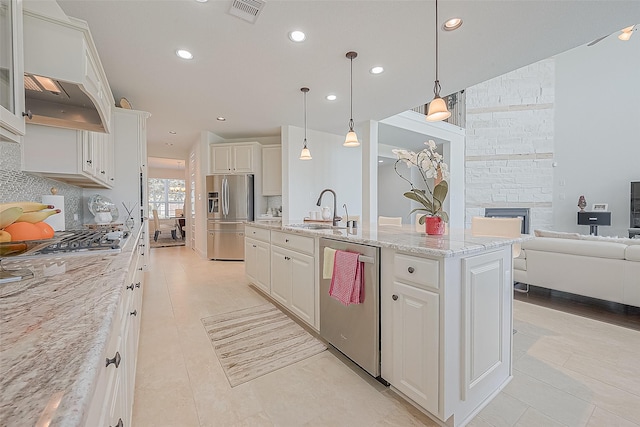 47 Monarch Trl, Sugar Land, TX 77498 - kitchen with appliances with stainless steel finishes, white cabinetry, an island with sink, tasteful backsplash, and recessed lighting