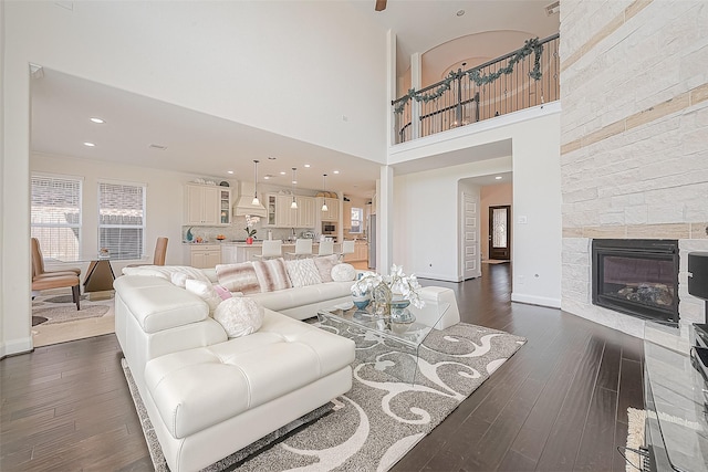 47 Monarch Trl, Sugar Land, TX 77498 - living room with dark wood-style flooring, a fireplace, a towering ceiling, and recessed lighting