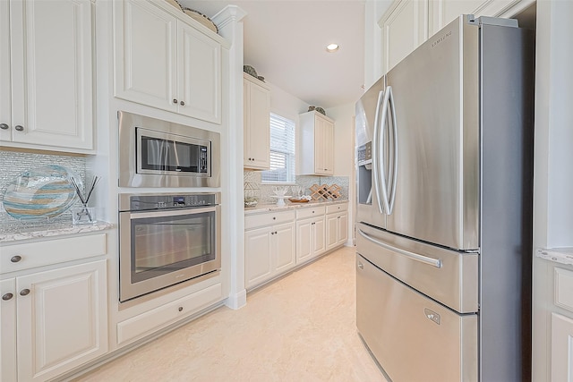 47 Monarch Trl, Sugar Land, TX 77498 - kitchen featuring stainless steel appliances, tasteful backsplash, recessed lighting, white cabinets, and light stone countertops