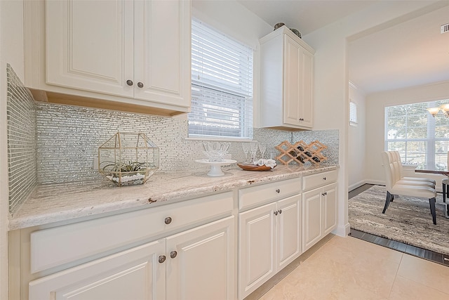 47 Monarch Trl, Sugar Land, TX 77498 - kitchen featuring tasteful backsplash, light tile patterned floors, white cabinetry, and light stone counters