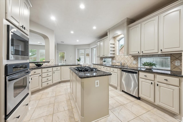 12410 Sonata Canyon Ln, Houston, TX 77041 - kitchen featuring appliances with stainless steel finishes, recessed lighting, light marble finish floors, dark stone counters, and backsplash