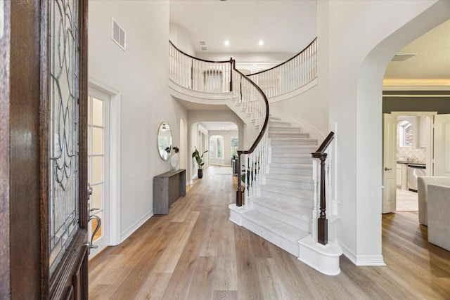 12410 Sonata Canyon Ln, Houston, TX 77041 - foyer featuring arched walkways, plenty of natural light, a towering ceiling, stairway, and wood finished floors