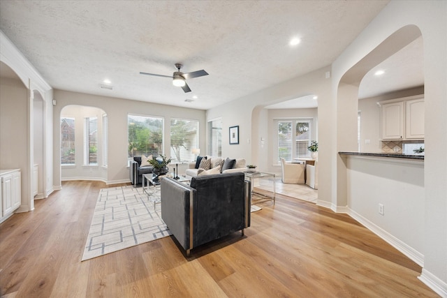 12410 Sonata Canyon Ln, Houston, TX 77041 - living area featuring arched walkways, light wood-style floors, ceiling fan, healthy amount of natural light, and recessed lighting