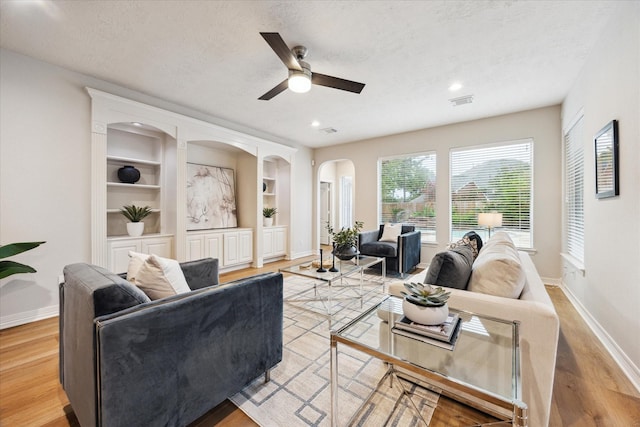 12410 Sonata Canyon Ln, Houston, TX 77041 - living area featuring a textured ceiling, arched walkways, ceiling fan, light wood-style floors, and built in features