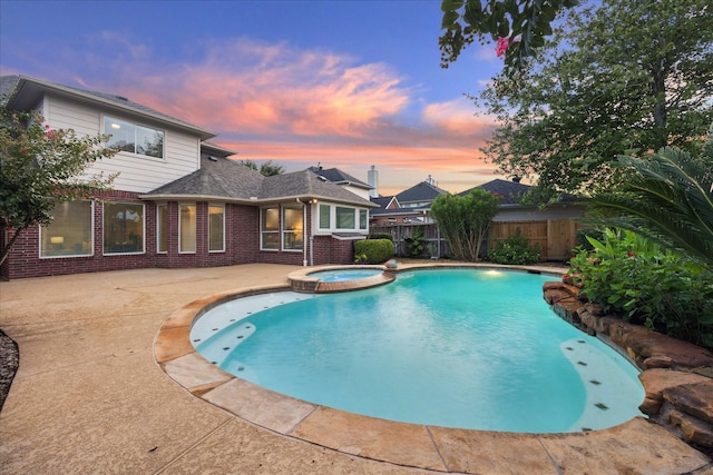 12410 Sonata Canyon Ln, Houston, TX 77041 - pool at dusk featuring a patio area, a pool with connected hot tub, and a fenced backyard