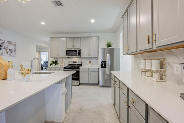 29918 Reagans Ranch Dr, Katy, TX 77494 - kitchen featuring stainless steel appliances, gray cabinets, decorative backsplash, light countertops, and recessed lighting