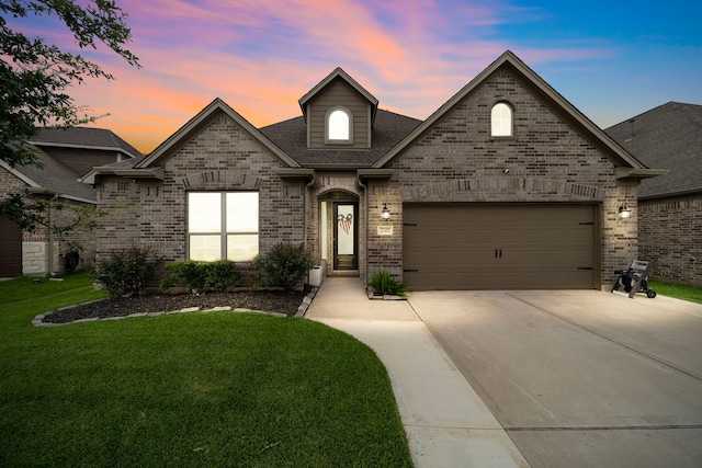 2707 Wollemi Pine Trl, Katy, TX 77493 - french country style house featuring a lawn, concrete driveway, brick siding, an attached garage, and a shingled roof
