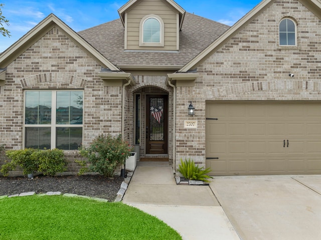 2707 Wollemi Pine Trl, Katy, TX 77493 - view of front facade featuring roof with shingles, brick siding, concrete driveway, and a garage
