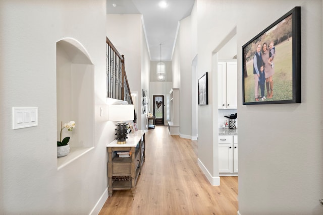 2707 Wollemi Pine Trl, Katy, TX 77493 - hallway with light wood-style floors, stairway, and a towering ceiling