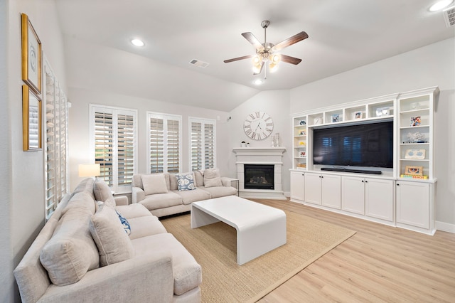 2707 Wollemi Pine Trl, Katy, TX 77493 - living room with light wood-type flooring, ceiling fan, lofted ceiling, a glass covered fireplace, and recessed lighting