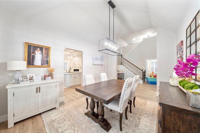 2707 Wollemi Pine Trl, Katy, TX 77493 - dining space featuring light wood-style floors, high vaulted ceiling, stairway, and a chandelier