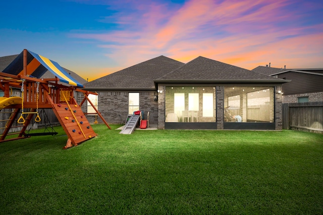 2707 Wollemi Pine Trl, Katy, TX 77493 - rear view of property featuring a playground, a shingled roof, and brick siding
