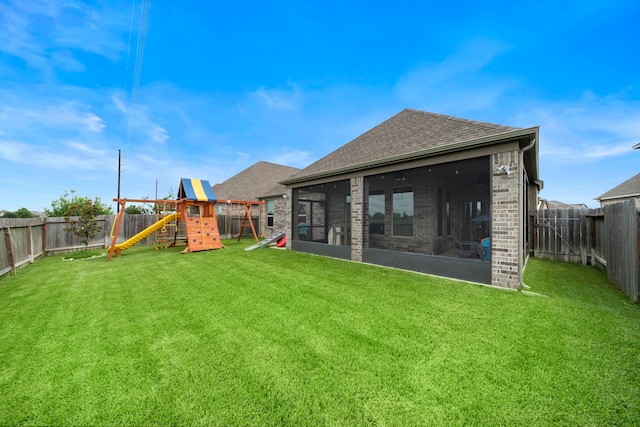 2707 Wollemi Pine Trl, Katy, TX 77493 - back of house with a sunroom, a playground, a shingled roof, a fenced backyard, and brick siding