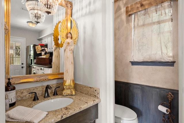 5610 Edgewick Ct, Houston, TX 77069 - half bathroom featuring vanity, a chandelier, washer / dryer, and a wainscoted wall
