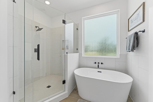 8302 Springwood Canyon Ln, Houston, TX 77055 - full bath featuring a soaking tub, a shower stall, tile walls, and wood finished floors