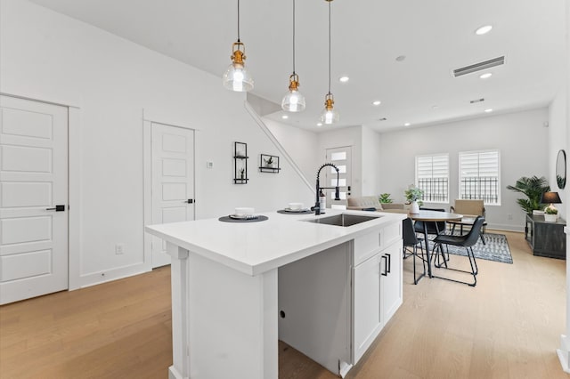 8302 Springwood Canyon Ln, Houston, TX 77055 - kitchen with light wood-type flooring, light countertops, decorative light fixtures, white cabinets, and recessed lighting
