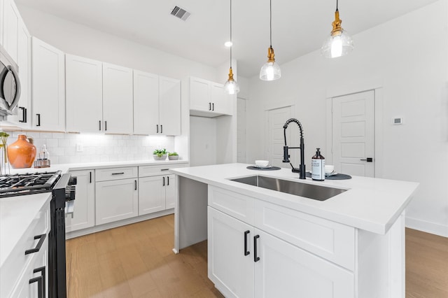 8302 Springwood Canyon Ln, Houston, TX 77055 - kitchen with gas range, backsplash, light wood-type flooring, white cabinets, and recessed lighting
