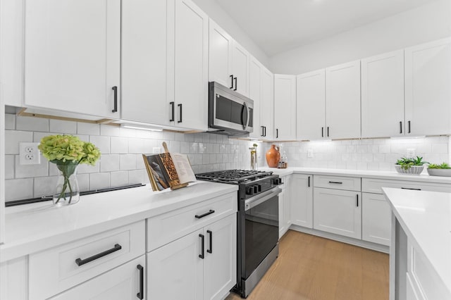 8302 Springwood Canyon Ln, Houston, TX 77055 - kitchen with appliances with stainless steel finishes, light countertops, and white cabinets