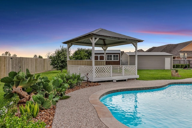 9826 Palm Dr, Mont Belvieu, TX 77523 - pool at dusk with an outbuilding