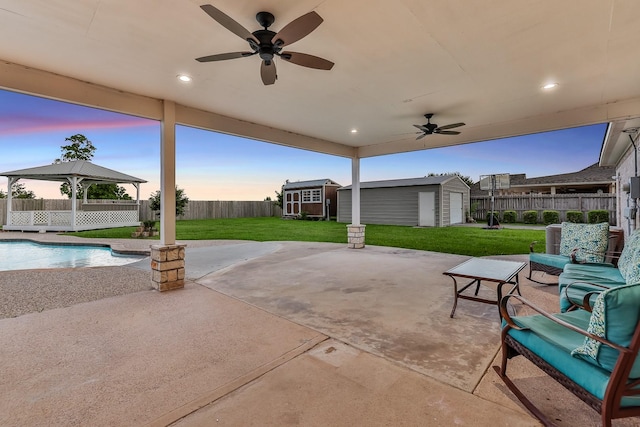 9826 Palm Dr, Mont Belvieu, TX 77523 - fenced backyard with a gazebo, a storage shed, a ceiling fan, and a patio area