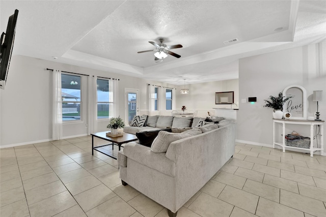 9826 Palm Dr, Mont Belvieu, TX 77523 - living room with a tray ceiling, ceiling fan, a textured ceiling, and light tile patterned floors