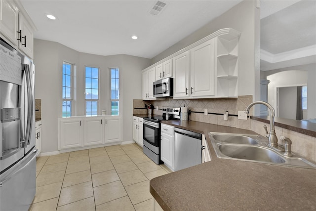 9826 Palm Dr, Mont Belvieu, TX 77523 - kitchen with stainless steel appliances, open shelves, backsplash, dark countertops, and white cabinets