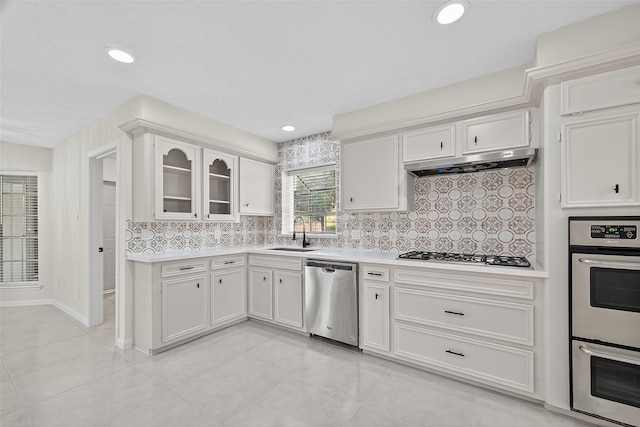 19502 Enchanted Oaks Dr, Spring, TX 77388 - kitchen with stainless steel appliances, light countertops, tasteful backsplash, light tile patterned flooring, and white cabinetry
