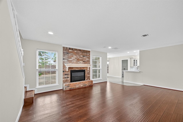19502 Enchanted Oaks Dr, Spring, TX 77388 - unfurnished living room featuring dark wood-type flooring, a brick fireplace, and recessed lighting