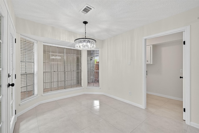 19502 Enchanted Oaks Dr, Spring, TX 77388 - unfurnished dining area featuring a textured ceiling, light tile patterned flooring, and a chandelier