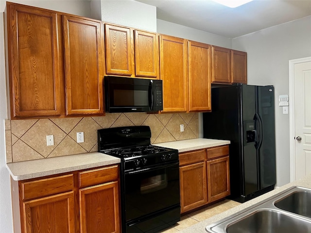 8303 Gros Ventre Ln, Houston, TX 77095 - kitchen with black appliances, light countertops, backsplash, and brown cabinetry