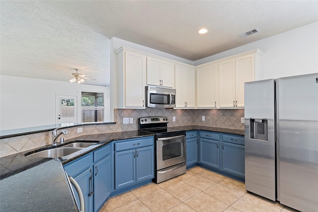 23307 W Pine Ivy Ln, Tomball, TX 77375 - kitchen with stainless steel appliances, blue cabinets, backsplash, light tile patterned flooring, and dark stone countertops