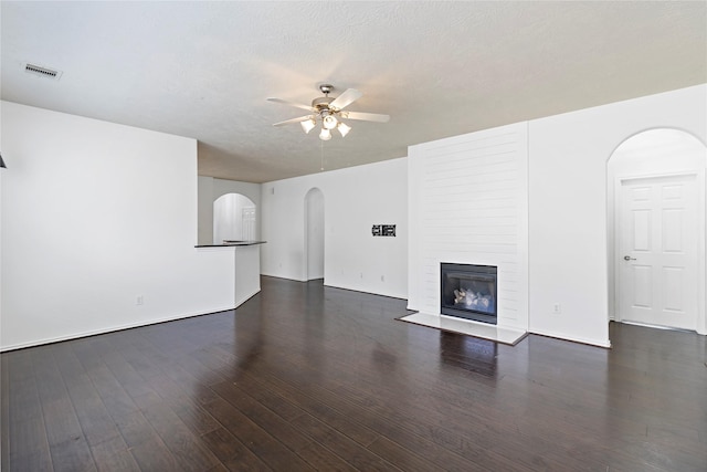 23307 W Pine Ivy Ln, Tomball, TX 77375 - unfurnished living room with arched walkways, ceiling fan, and wood finished floors