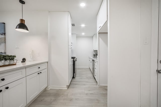 4330 Heite St, Houston, TX 77022 - kitchen with white cabinets, light wood finished floors, light countertops, decorative light fixtures, and recessed lighting