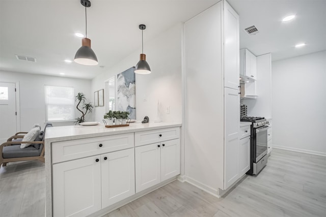 4330 Heite St, Houston, TX 77022 - kitchen with stainless steel gas range oven, white cabinetry, a peninsula, light wood-style floors, and light countertops