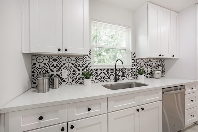 4330 Heite St, Houston, TX 77022 - kitchen featuring stainless steel dishwasher, backsplash, white cabinetry, and light stone counters