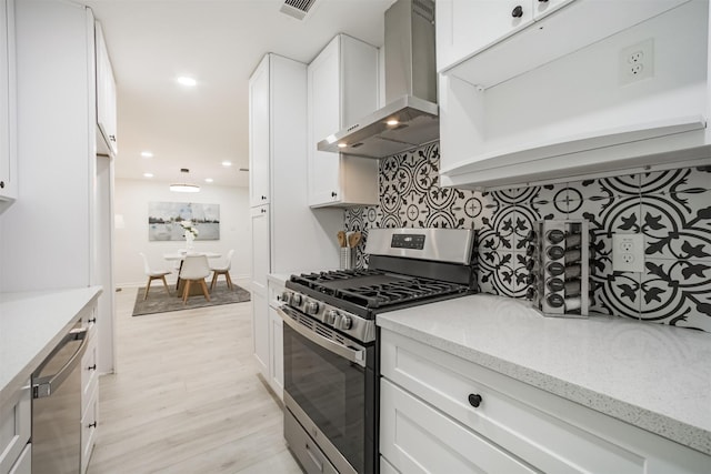 4330 Heite St, Houston, TX 77022 - kitchen featuring appliances with stainless steel finishes, wall chimney exhaust hood, backsplash, white cabinetry, and light stone countertops