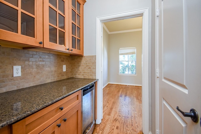 5615 Winsome Ln Unit C, Houston, TX 77057 - kitchen featuring wine cooler, ornamental molding, light wood-style floors, glass insert cabinets, and decorative backsplash