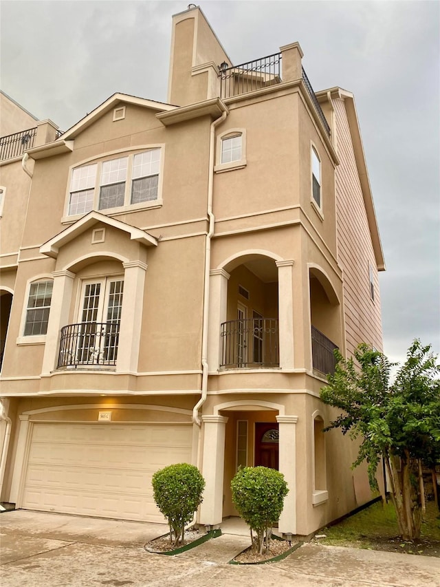 5615 Winsome Ln Unit C, Houston, TX 77057 - view of front of house with an attached garage, a balcony, concrete driveway, and stucco siding