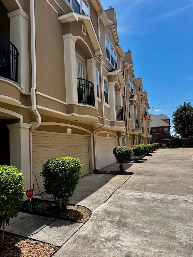 5615 Winsome Ln Unit C, Houston, TX 77057 - view of building exterior with a residential view, an attached garage, and driveway