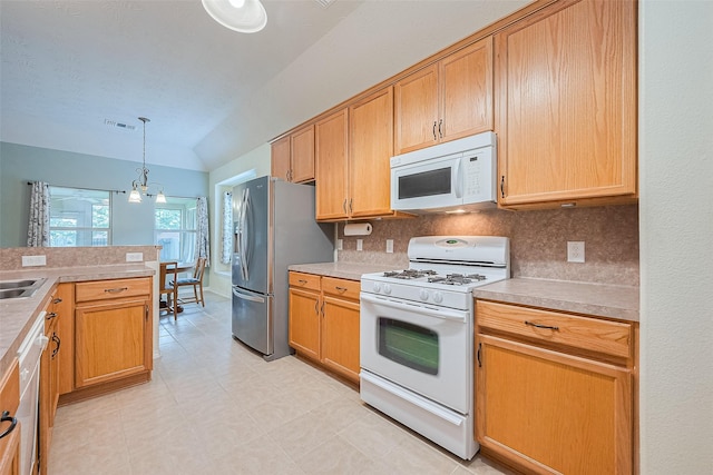 30606 S Sulphur Creek Dr, Magnolia, TX 77355 - kitchen with white appliances, decorative light fixtures, light countertops, and vaulted ceiling