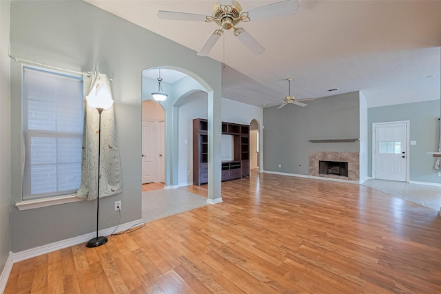 30606 S Sulphur Creek Dr, Magnolia, TX 77355 - unfurnished living room featuring a ceiling fan, arched walkways, wood finished floors, and a fireplace